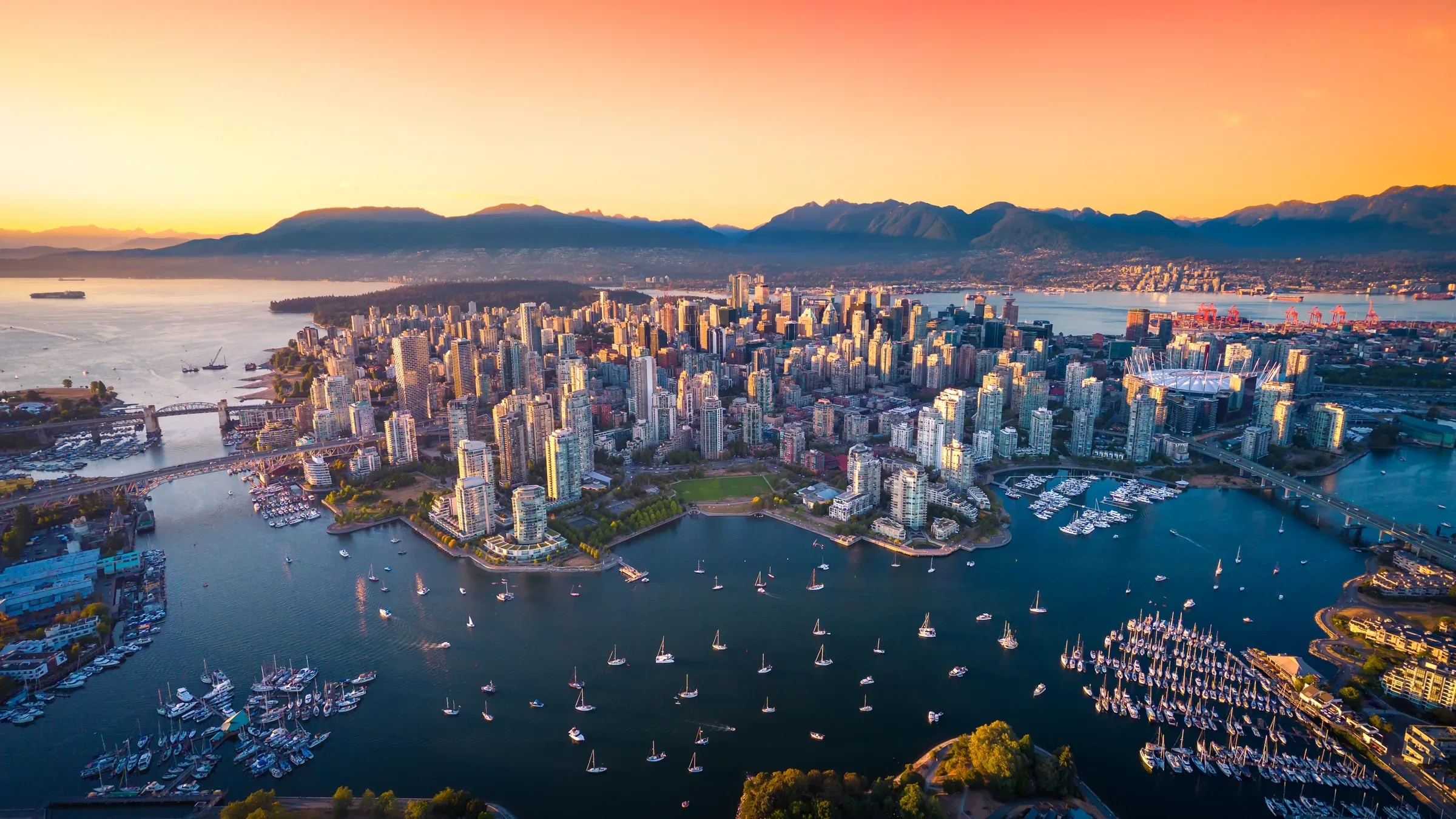 Aerial view of a waterfront downtown skyline at sunset